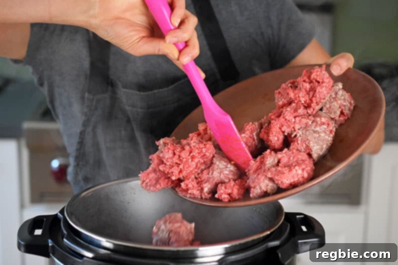 A woman is adding ground beef from a plate into an open Instant Pot.