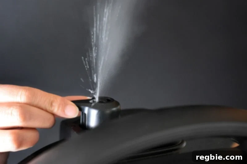 A hand carefully turning the pressure release valve on an Instant Pot, with visible steam escaping, a critical step after pressure cooking.