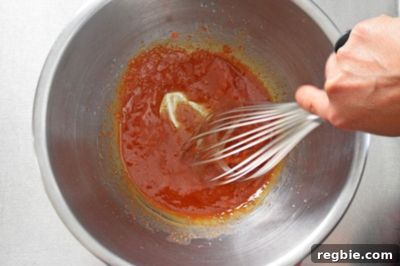 Whisking all the ingredients thoroughly to create a cohesive and aromatic marinade for Sheet Pan Chicken Fajitas.