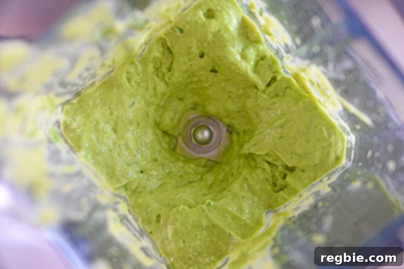An overhead shot of smooth, creamy Avocado Crema in an open Vitamix blender, ready to be served.