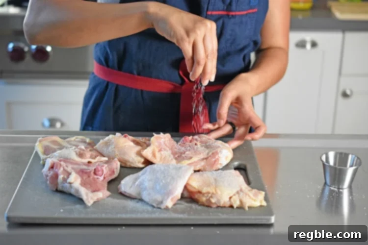 Golden-Crisp Cantonese Chicken Thighs 6 Sprinkling salt on chicken thighs on a cutting board