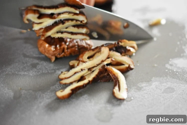 Golden-Crisp Cantonese Chicken Thighs 8 Closeup of thinly slicing rehydrated shiitake mushrooms.