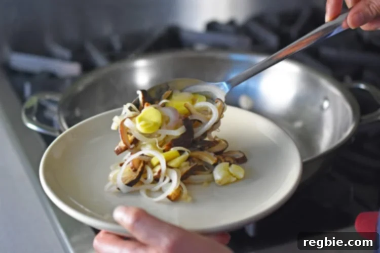 Golden-Crisp Cantonese Chicken Thighs 10 Transferring the sautéed aromatics and mushrooms from the pan to a plate.