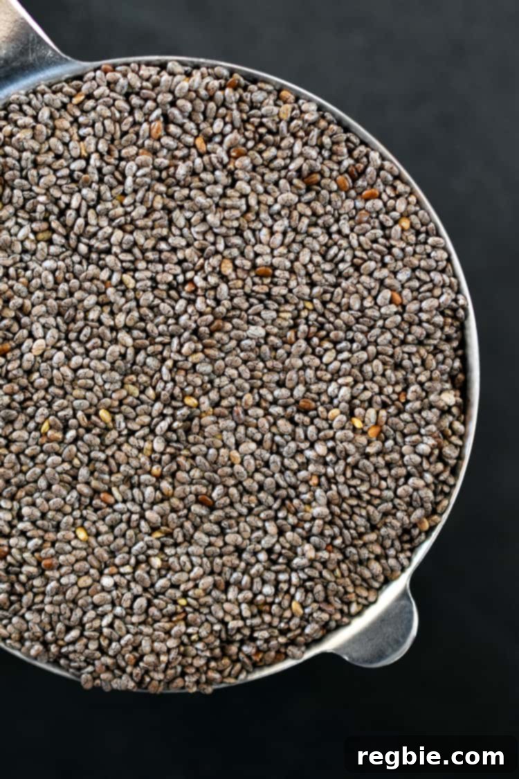 A closeup of dry chia seeds in a measuring cup.