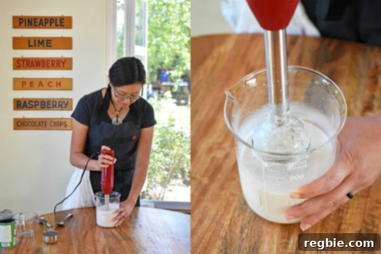 A woman is using an immersion blender to mix the ingredients for the coconut chia pudding.