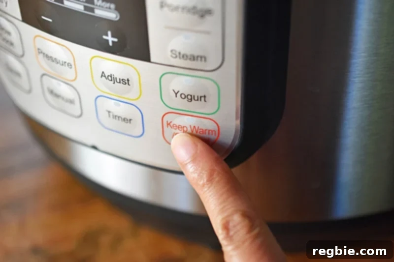 A finger is pressing the Keep Warm/Cancel button on an Instant Pot to end sauté mode.
