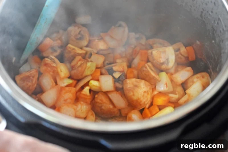 Sauteeing the ingredients of Instant Pot Summer Italian Chicken with some tomato paste and garlic.