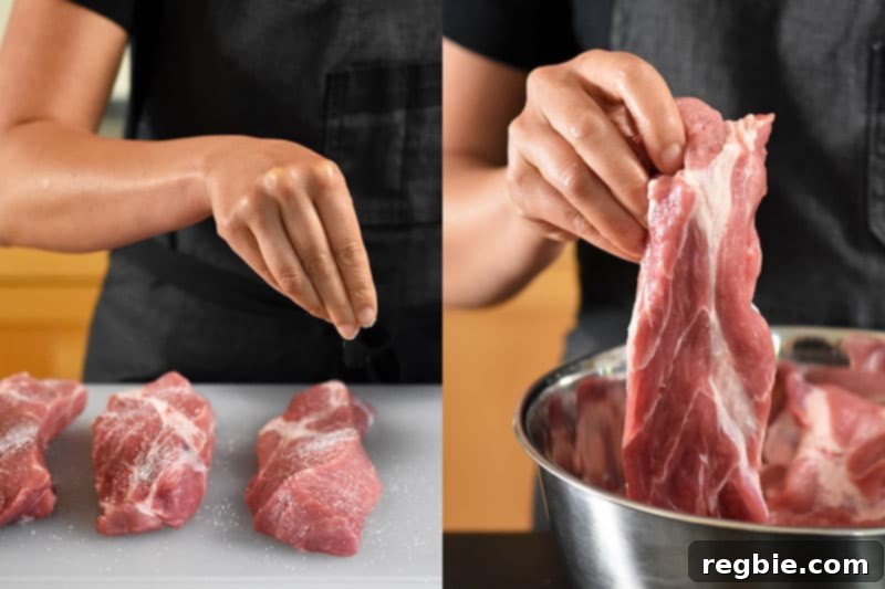 A hand sprinkling Diamond Crystal kosher salt evenly over pieces of boneless pork shoulder before marination for Paleo Char Siu.