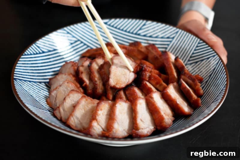 Pieces of Paleo Char Siu (Chinese BBQ Pork) artfully arranged in a spiral pattern in a white Japanese serving bowl.