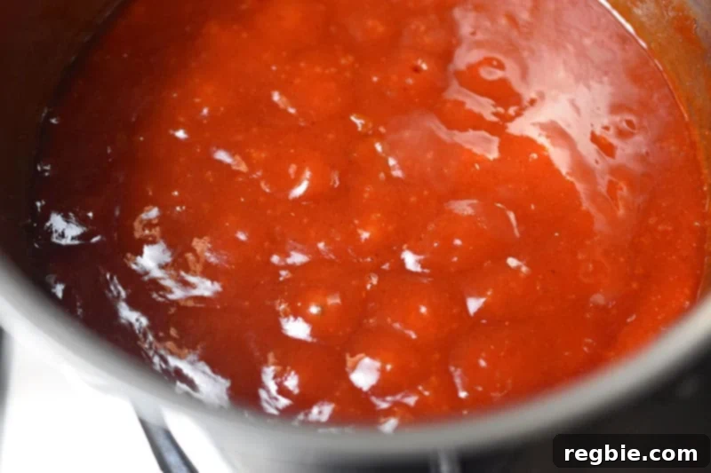 The simmering, sticky Char Siu sauce is transferred to a measuring cup to cool to room temperature.