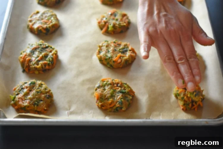A hand is shown pressing down paleo Curry Turkey Bites into flat patties.