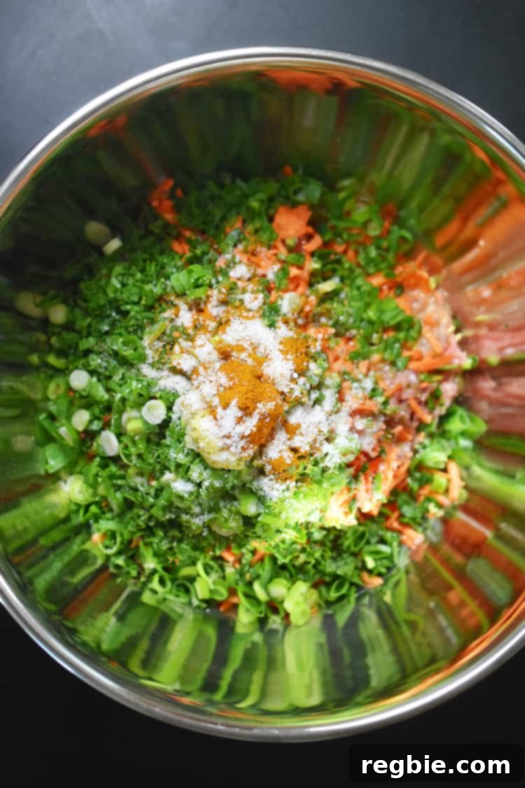 An overhead shot showcasing the vibrant medley of raw ingredients for Curry Turkey Bites in a mixing bowl, emphasizing the generous amount of vegetables.