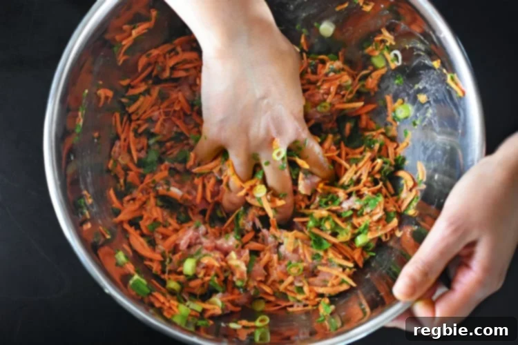 Hands are shown expertly mixing the raw ingredients for Curry Turkey Bites in a large silver bowl, ensuring all components are well combined without overworking the mixture.