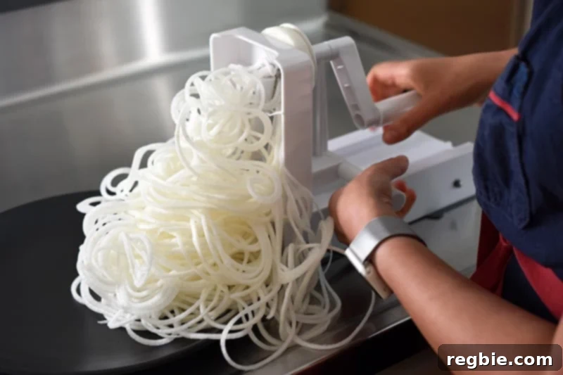 Someone expertly using a spiralizer to create long, delicate daikon noodles.