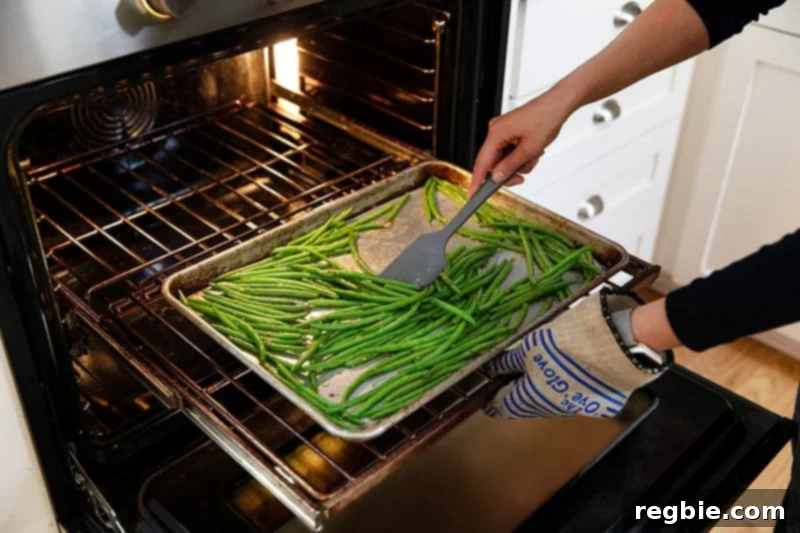 Crisp Lemon-Garlic Roasted Green Beans 8 Tossing the roasted green beans with a gray silicone spatula midway through roasting.