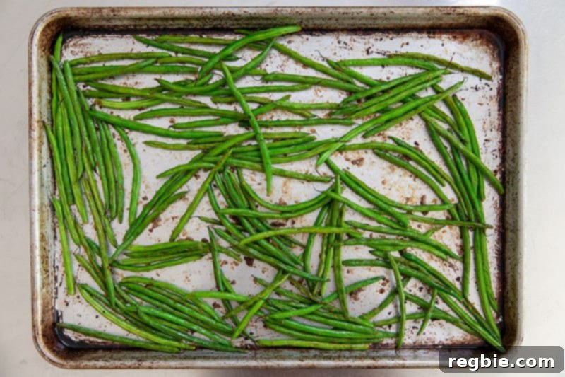 Crisp Lemon-Garlic Roasted Green Beans 9 An overhead shot of a rimmed baking sheet with roasted green beans with lemon and garlic.