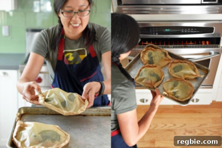 Four heart-shaped Fiona’s Phenomenal Fish Packets arranged on a rimmed baking sheet, ready for the oven.