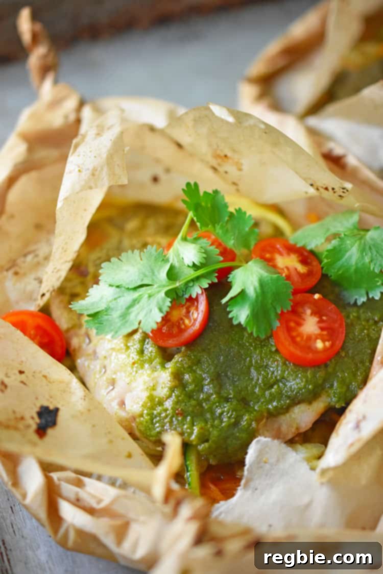 A close-up of an opened Fiona’s Phenomenal Fish Packet, showing the perfectly cooked fish, spiraled vegetables, and fresh cherry tomatoes.