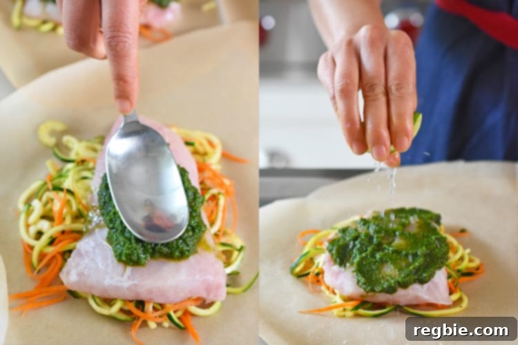Spooning the vibrant green marinade on top of a fish fillet within a parchment paper heart.