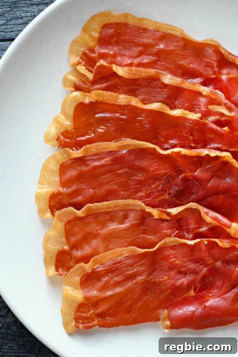 Golden Prosciutto Snaps 9 A white plate topped with crispy prosciutto slices