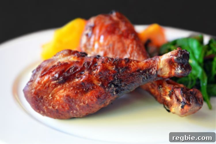 Wholesome Whole30 Cherry Chicken 2 A vibrant plate of cherry chicken served with fresh green vegetables, showcasing the rich color of the cherry glaze on the chicken.