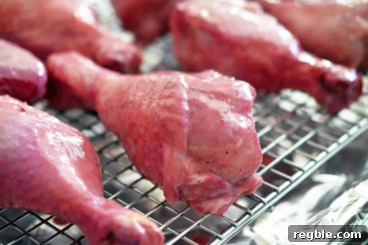Wholesome Whole30 Cherry Chicken 10 Marinated chicken drumsticks carefully arranged on a wire rack over a baking sheet, ready for the oven.