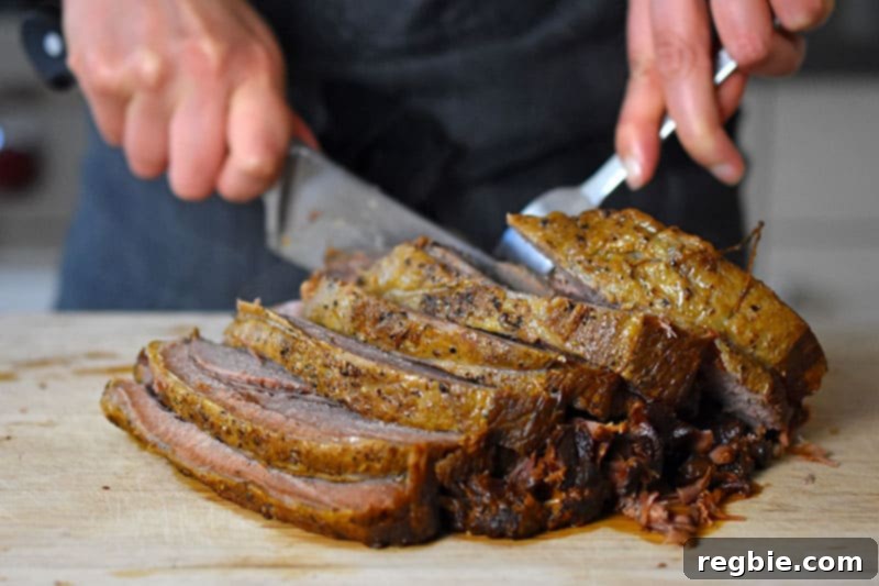 Instant Pot Yankee Pot Roast is sliced on a wooden cutting board