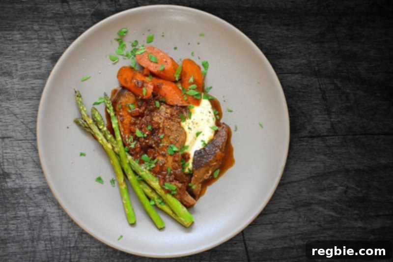 An overhead shot of a plate of Instant Pot Yankee Pot Roast on Garlic Cauliflower Mashed Potatoes and roasted asparagus