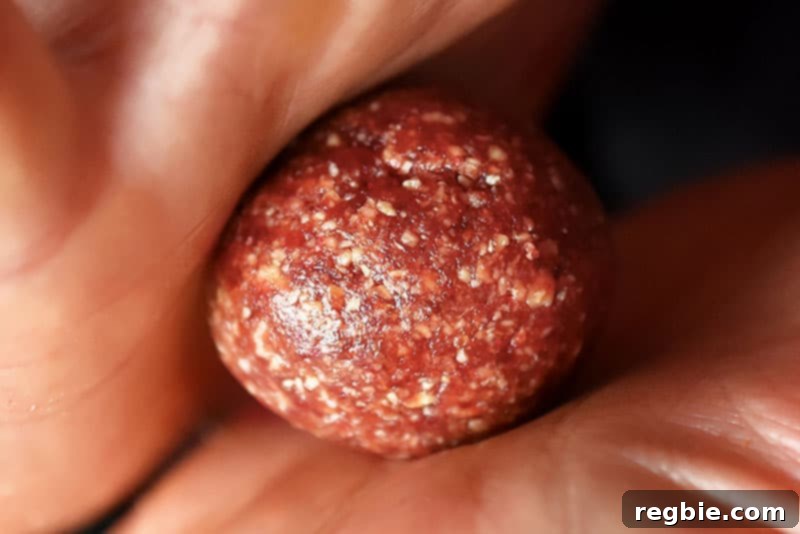 Peanut Butter Jelly Power Bites 9 Rolling “PB&J” Energy Balls in between two hands.
