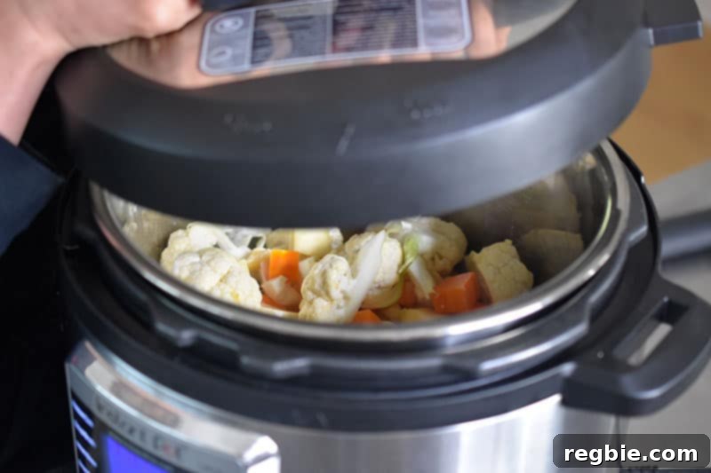 Instant Pot Wholesome Autumn Mash 11 A hand securely placing the lid onto the Instant Pot, with the valve visible in the sealed position.