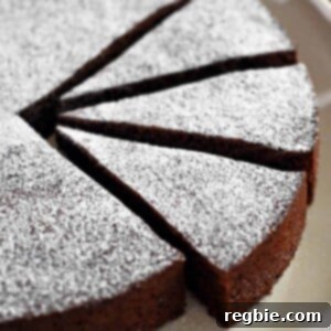 A tempting close-up shot of a Torta Caprese, a classic Italian almond flour chocolate cake, with three perfectly cut slices revealing its rich, dense texture.