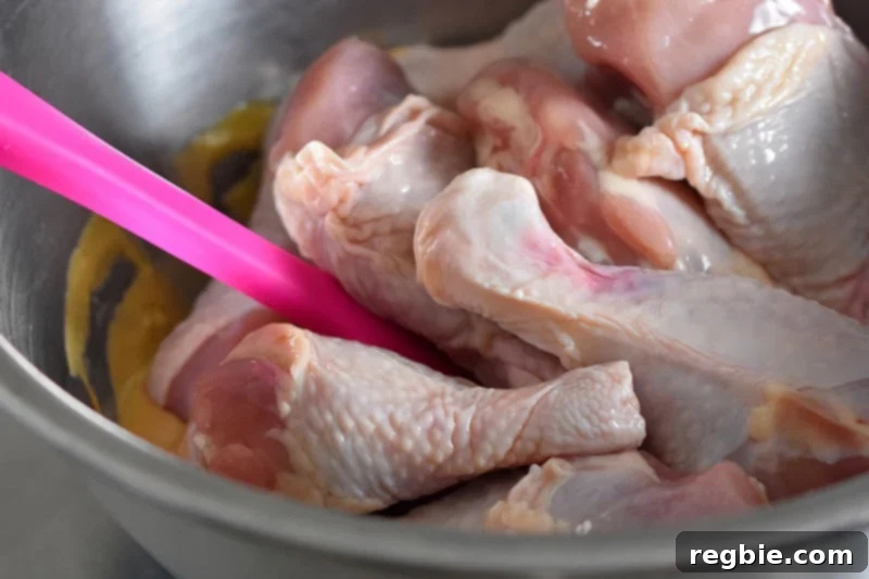Chicken drumsticks in a bowl of marinade.