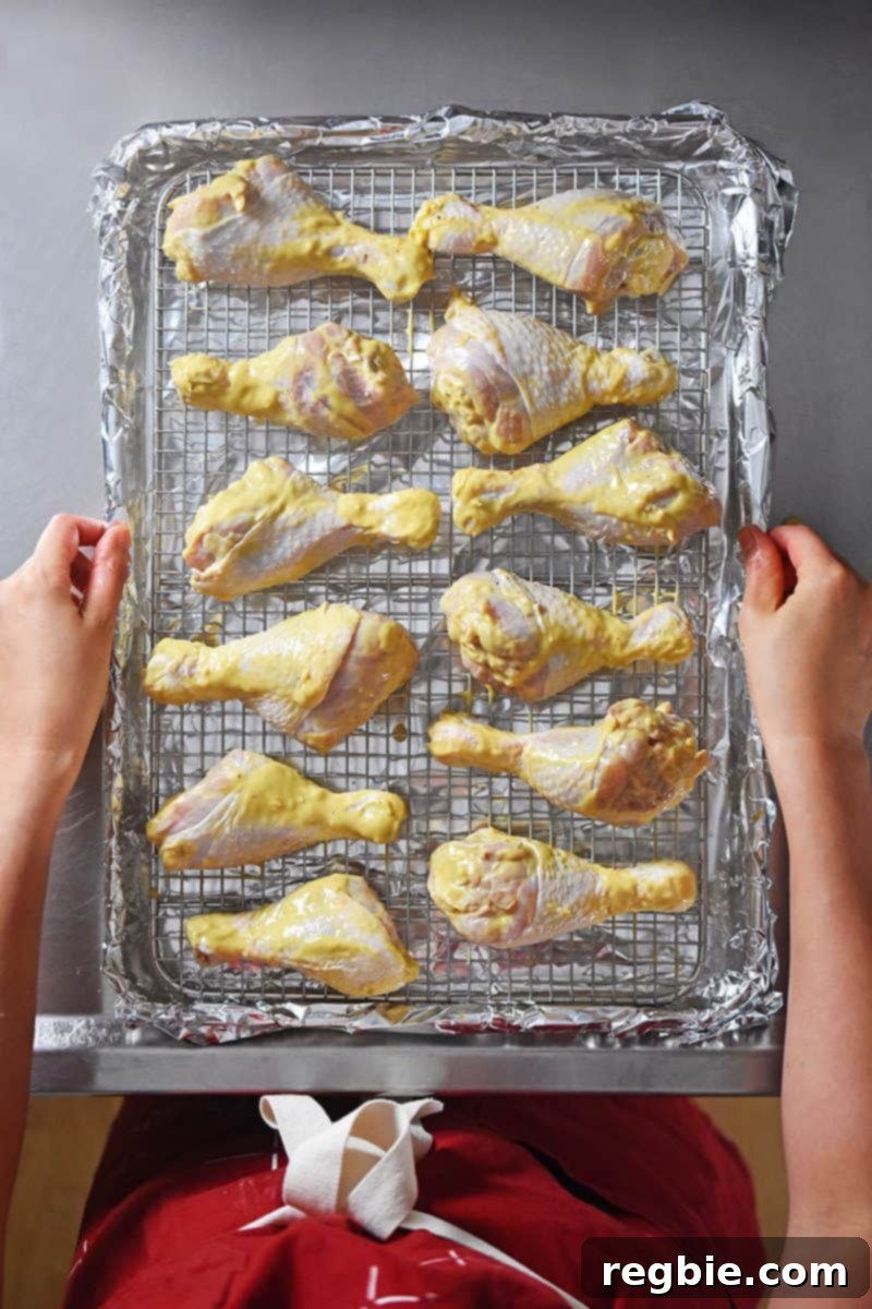 Orange dijon marinated chicken on a foil lined rack.