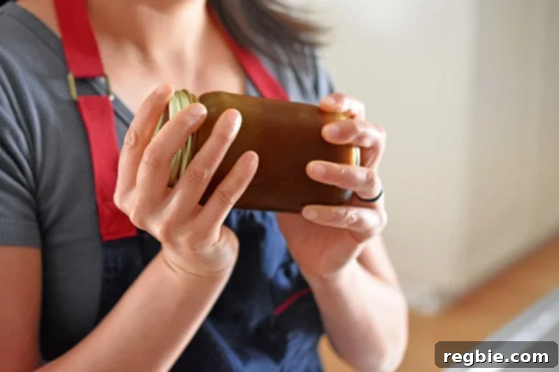 A mason jar filled with All-Purpose Stir-Fry Sauce being vigorously shaken, ensuring all ingredients are well combined.