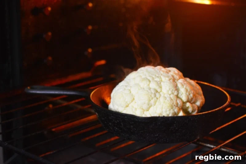 The foil cover is removed from the skillet, allowing the cauliflower to continue roasting and brown in the oven.