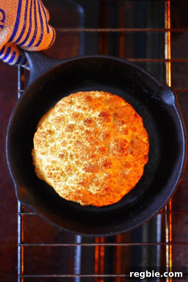 An overhead shot of the Whole Roasted Cauliflower, with a golden brown surface, ready to be taken out of the oven.