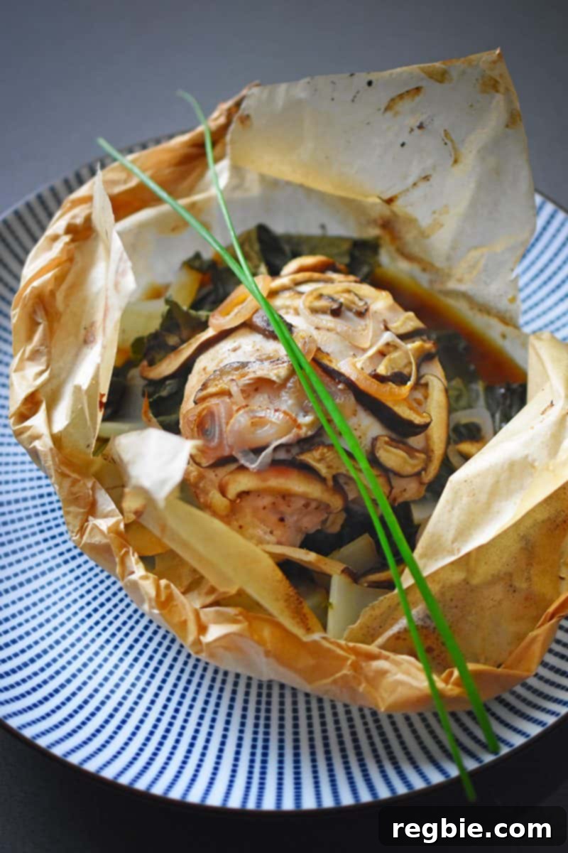 A packet of the paleo paper-wrapped chicken opened up to display the ingredients inside.