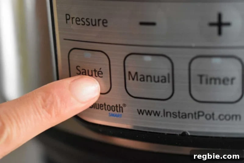Creamy Instant Pot Lemongrass Coconut Chicken 12 Someone pressing the sauté button on an Instant Pot to begin the cooking process for the chicken stew.