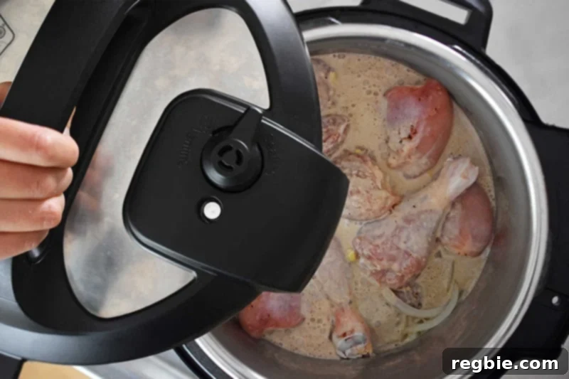 Creamy Instant Pot Lemongrass Coconut Chicken 15 Someone carefully placing and locking the lid onto the Instant Pot, preparing it for pressure cooking.