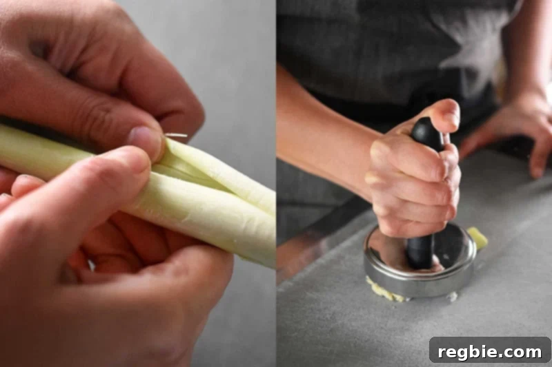 Someone preparing lemongrass by peeling and smashing it to release its aromatic oils.