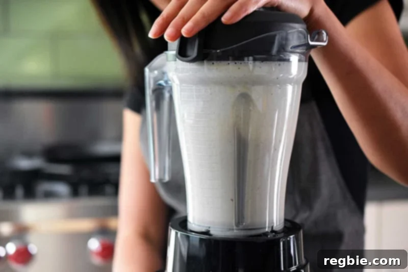 The high-speed blender mixing the lemongrass, coconut milk, and other ingredients into a smooth, fragrant sauce.