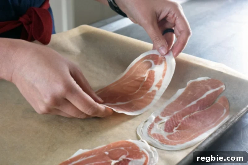 Golden Apple & Bitter Greens 5 Someone laying out slices of prosciutto on a baking sheet.