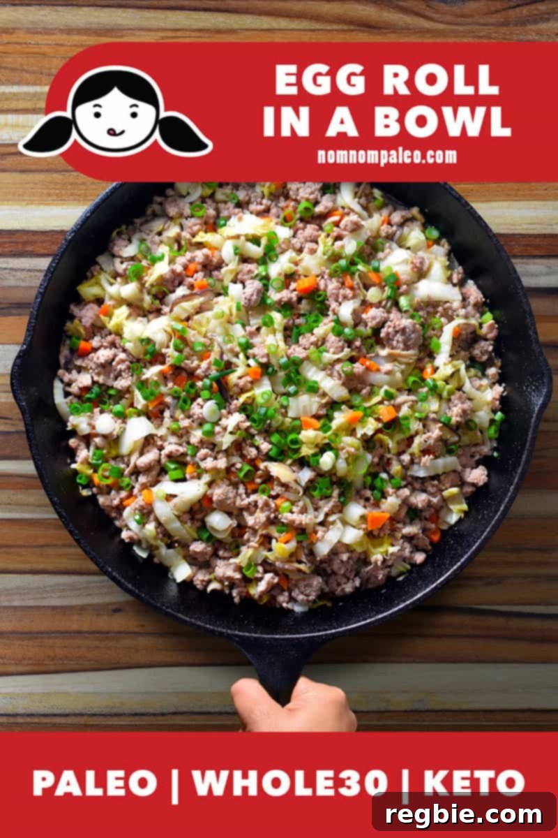 An overhead shot of a vibrant Egg Roll in a Bowl served in a cast iron skillet, highlighted with a banner indicating its Paleo, Keto, and Whole30 compliance.