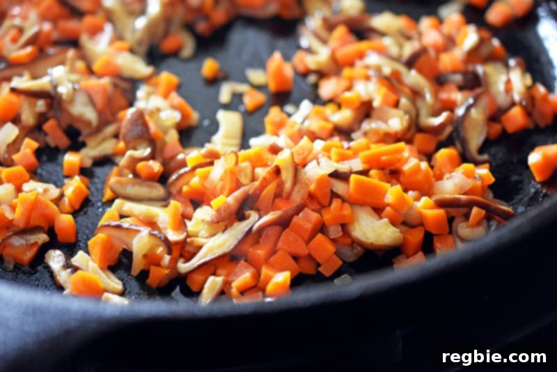 Sautéing carrots, shallots, and shiitake mushrooms in a cast iron skillet until perfectly softened for the stir-fry base.