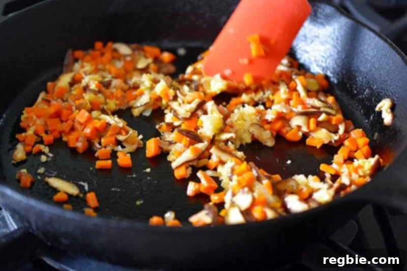 Minced garlic and grated ginger are added to the pan, ready to release their aromatic essence into the stir-fry.