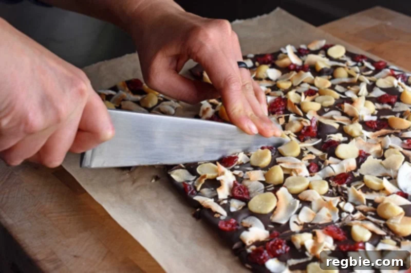 Coco-Nutty Dark Bark by Michelle Tam / Nom Nom Paleo https://nomnompaleo.com showing hardened chocolate bark being broken into pieces.