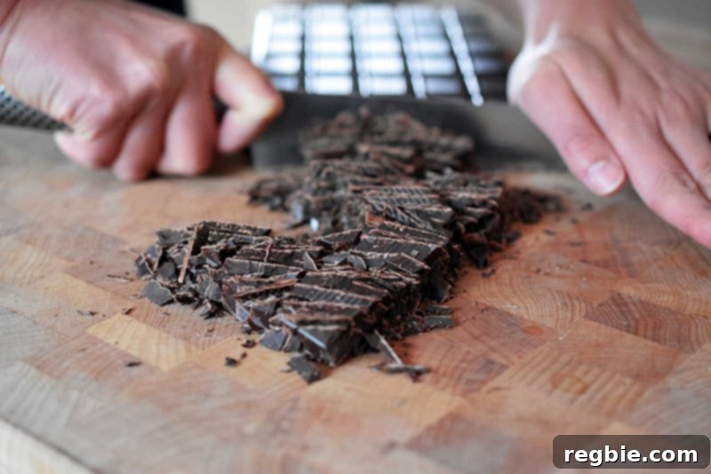 Coco-Nutty Dark Bark by Michelle Tam / Nom Nom Paleo https://nomnompaleo.com showing dark chocolate being chopped into small shards.