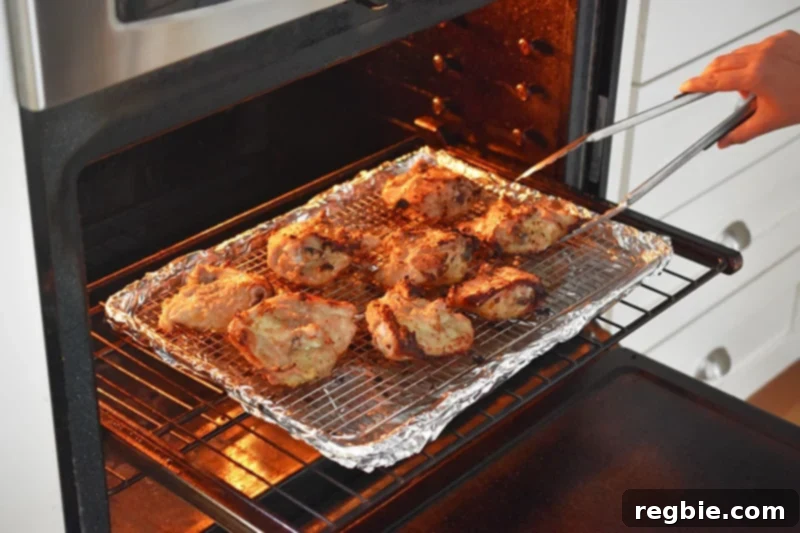 Flipping the Vietnamese Lemongrass Chicken thighs skin-side up in the oven to achieve a crispy, golden finish.