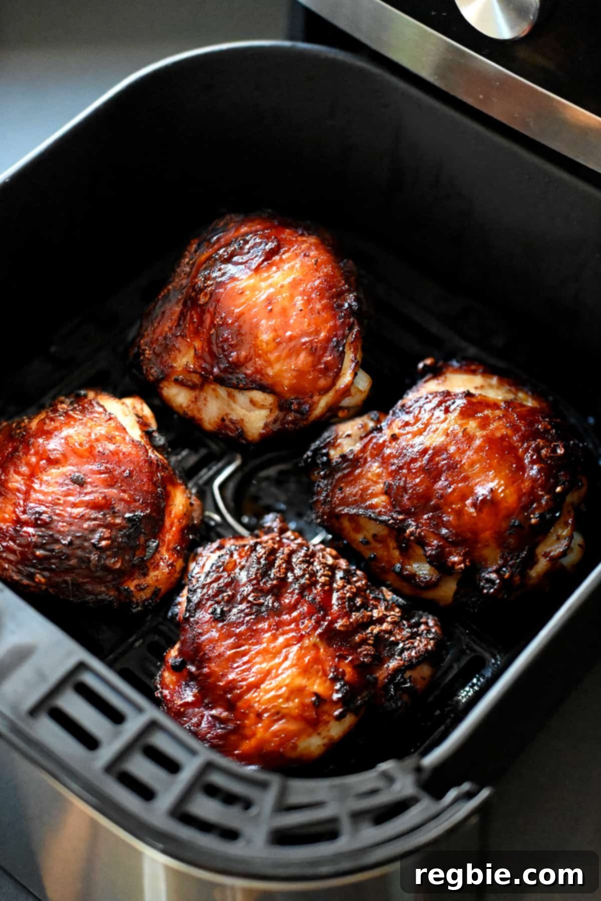 An open air fryer revealing golden brown, perfectly cooked paleo Vietnamese Lemongrass Chicken thighs.