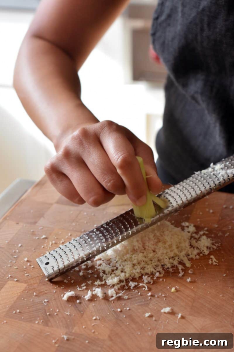 Using a microplane rasp grater to finely mince lemongrass, ensuring maximum flavor extraction for the marinade.